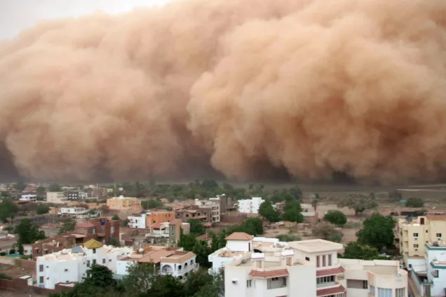 A huge cloud of dust and sand above a city in the Middle East.